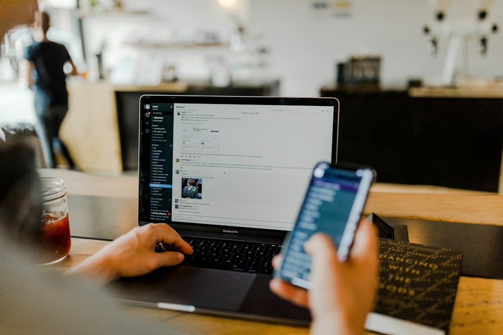 Medarbetare med laptop och mobiltelefon som hanterar arbetsuppgifter